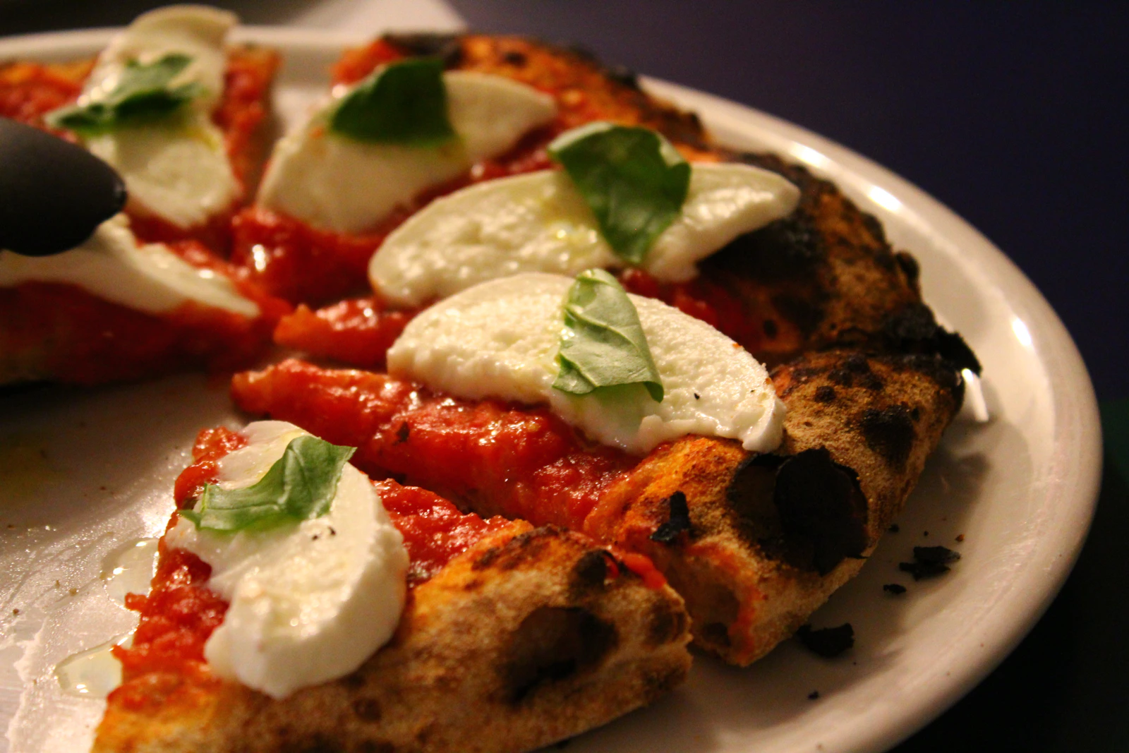 Vedugnsbakad pizza med mozzarella och färsk basilika